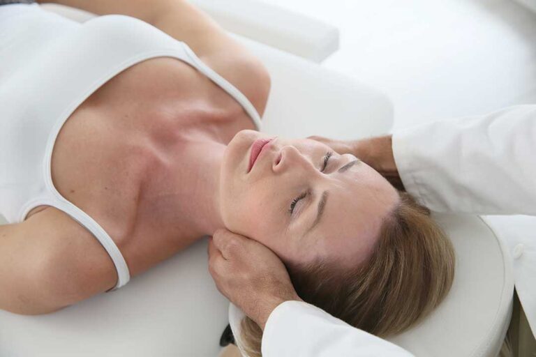 Person sleeping on their side with a pillow between their knees in a calm bedroom